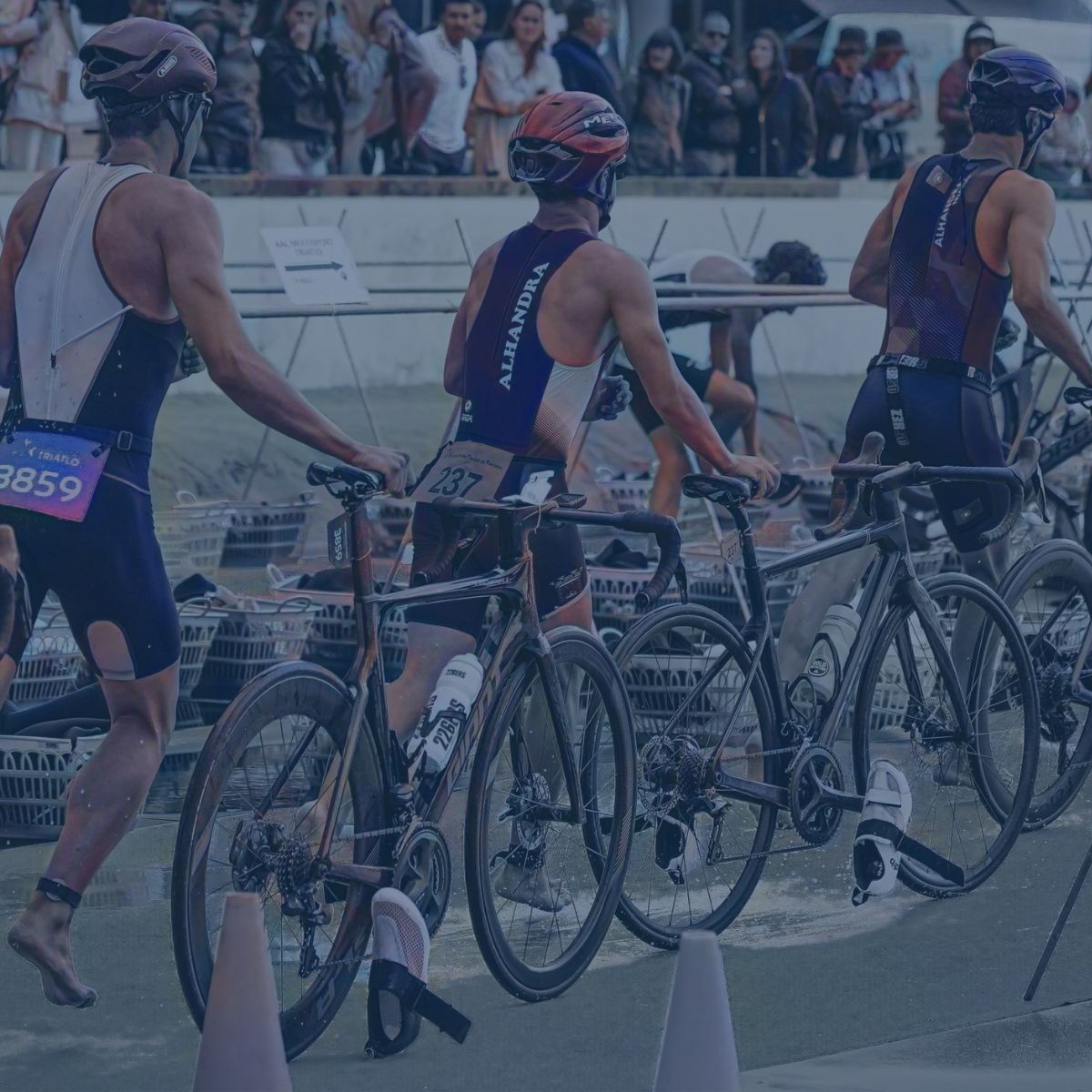 Triathlètes poussant leur vélo dans la zone de transition.